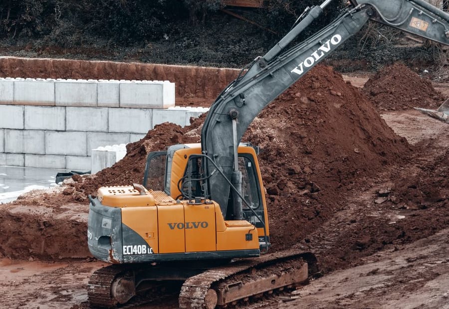 Excavator removing a failed drainfield to build a replacement mound on a rural lot near Rochester, Minnesota